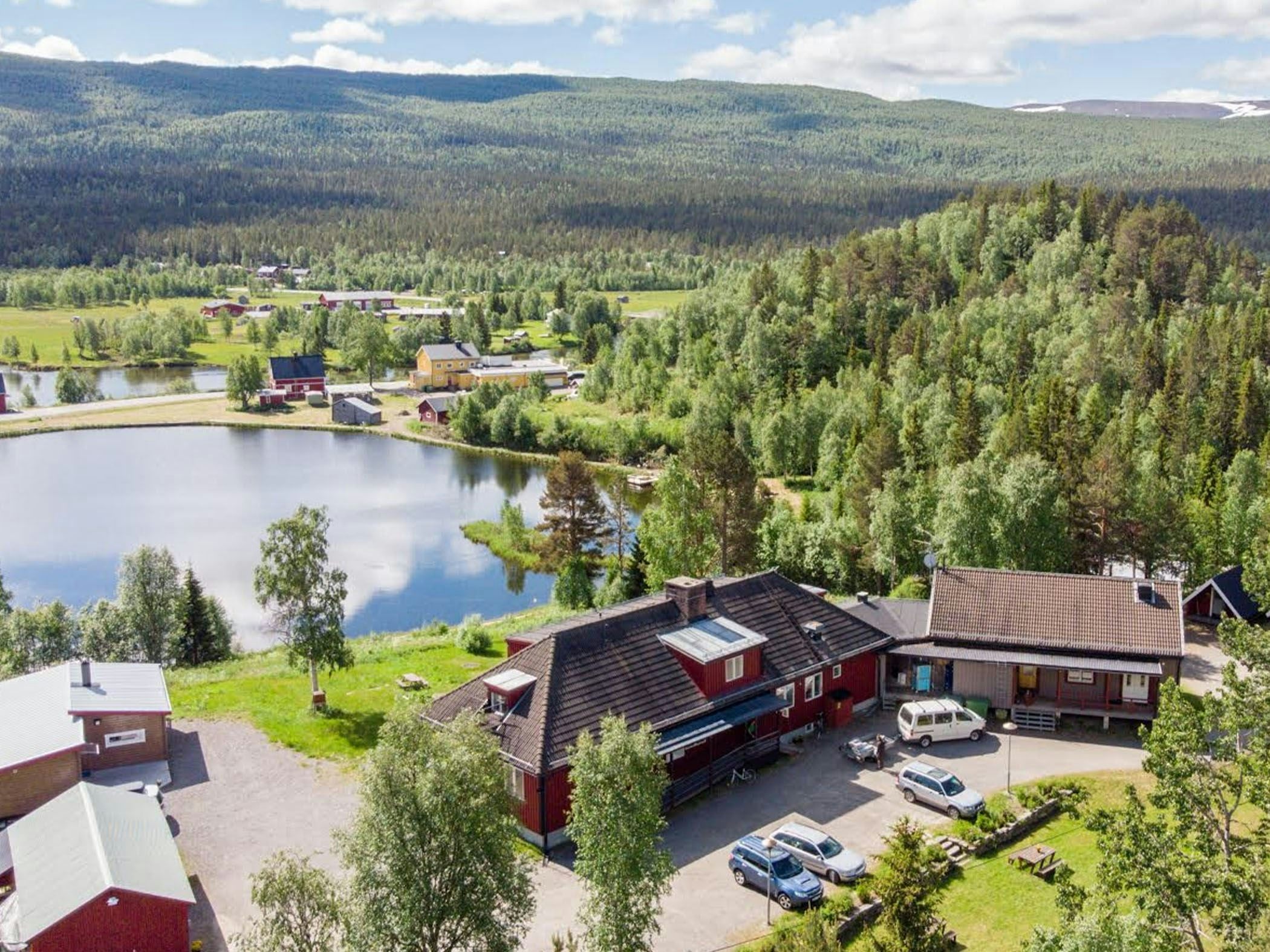 Inn by a small lake, surrounded by forest and mountain nature.