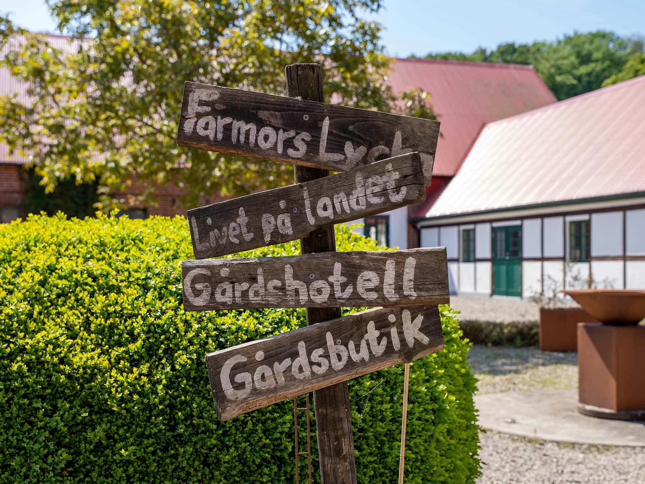 Eldstad framför tegelbyggnad med gröna dörrar och fönster.