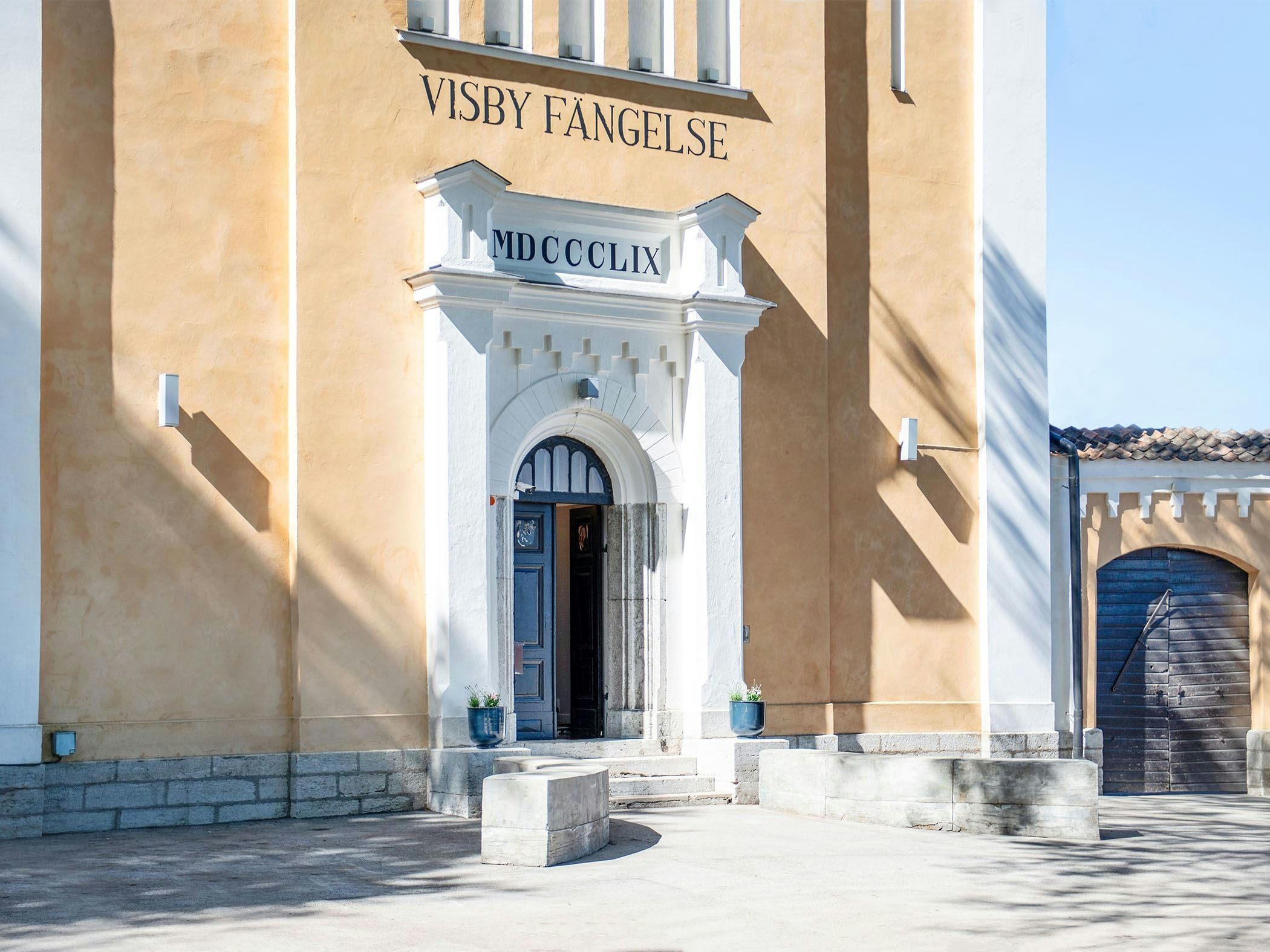 Visby vandrarhem med gul fasad och höga murar.
