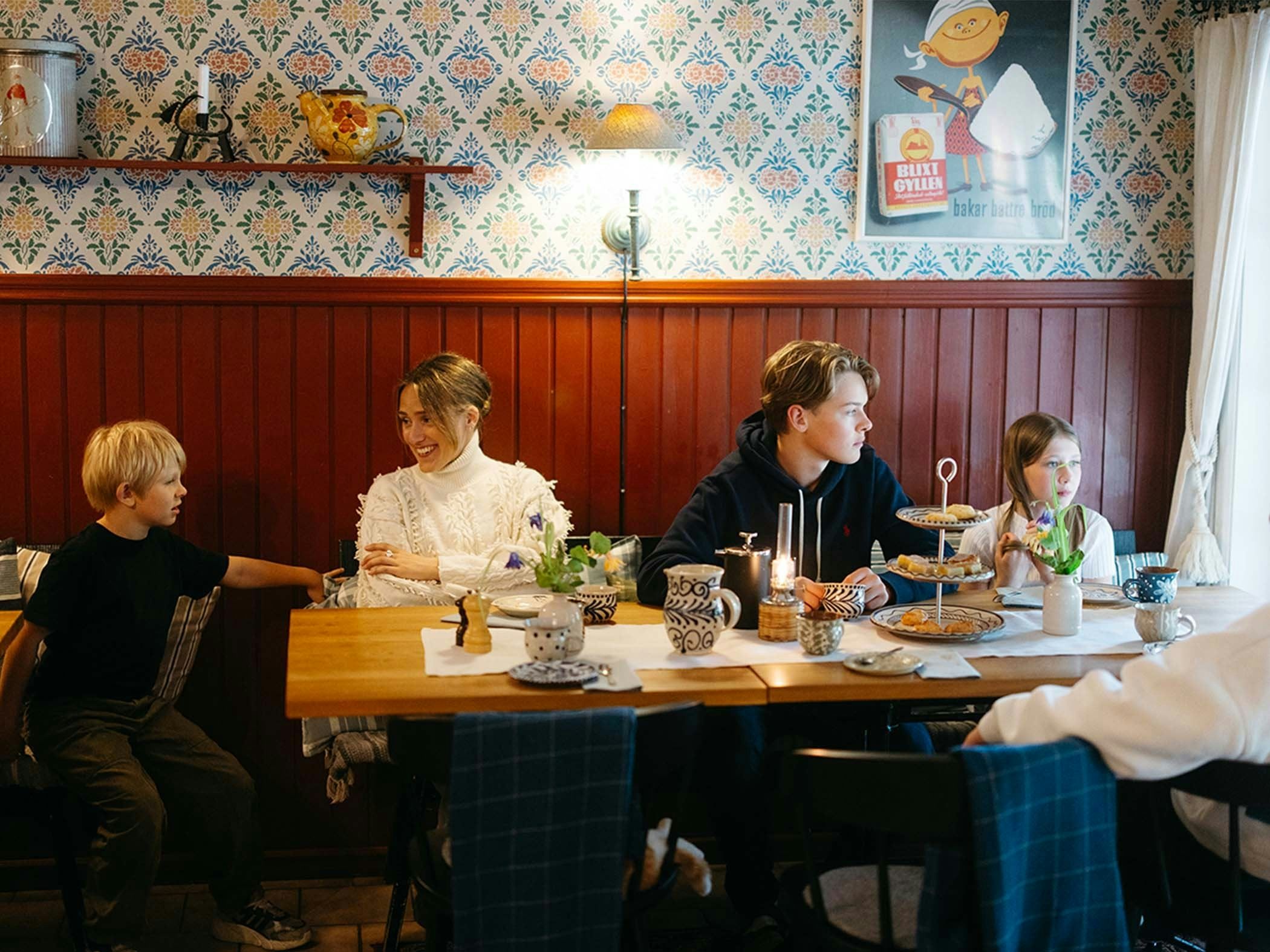 Familj äter middag i restaurangen på Wallby Säteri Gårdshotell.