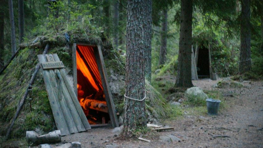 Grass-roofed earthen hut with wooden sign 