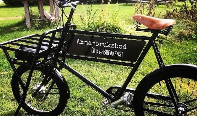 Black bicycle with the sign Axmarbruksbod Bed & Breakfast.