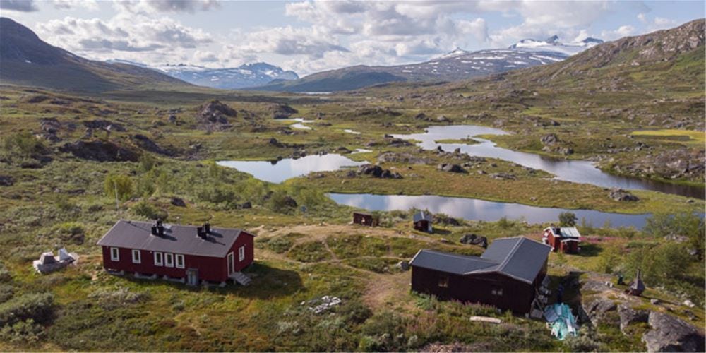 The vast expanses of the mountain world meet STF's red cabins in magical light.