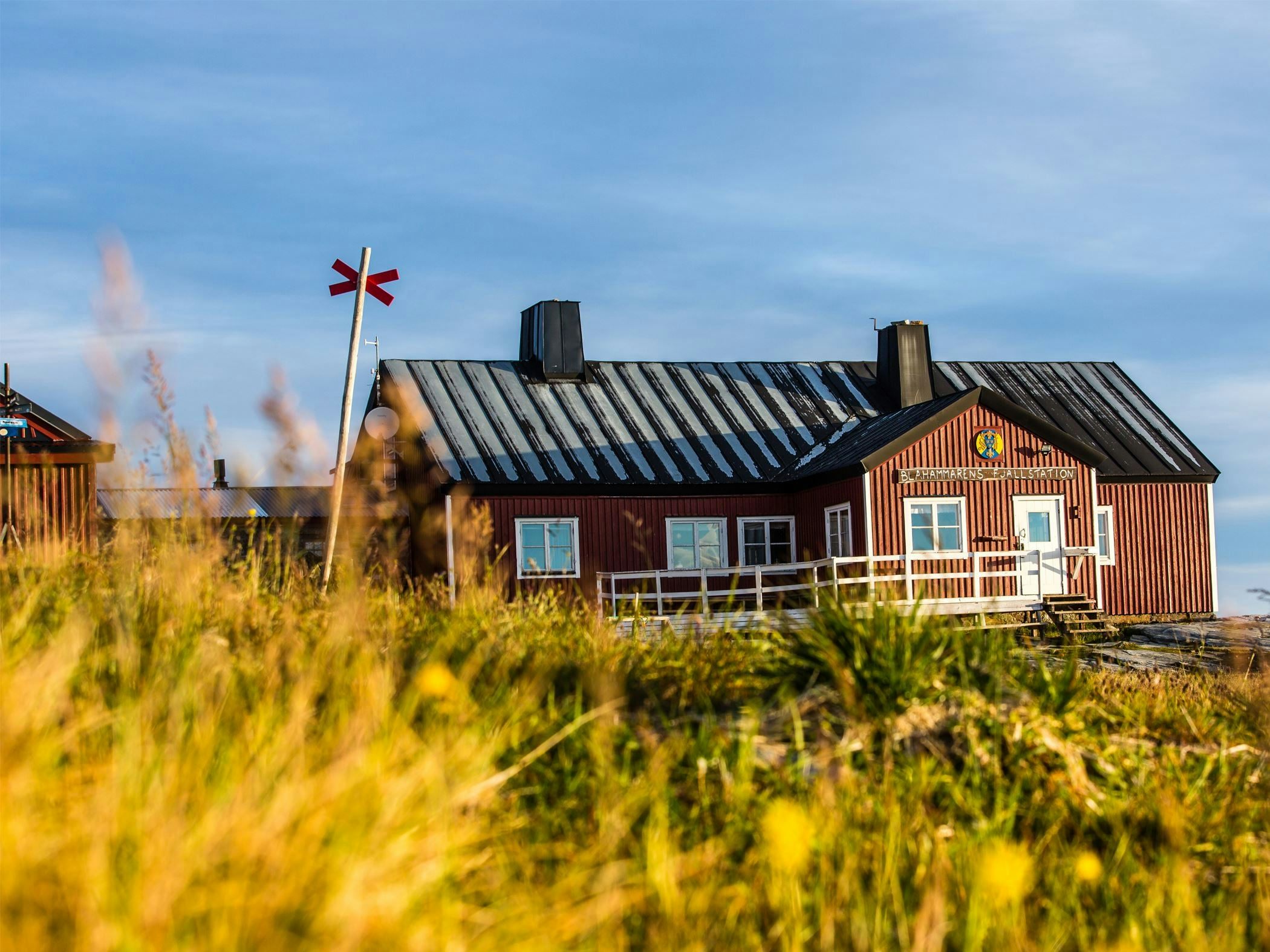 Fjällstation med röda byggnader i kargt högfjällslandskap.